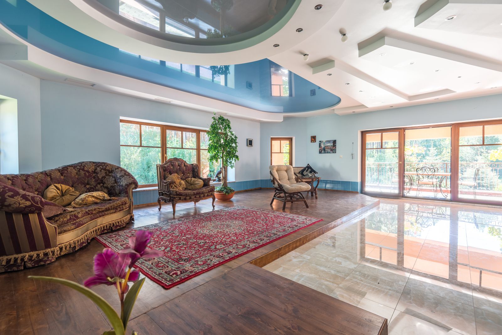 Bright living room with tall windows and a freshly painted multi-level ceiling